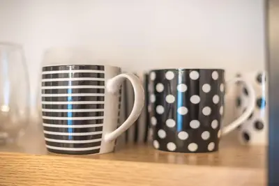 two black and white coffee mugs sitting on a shelf at Modern Apartment in Athens