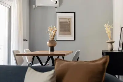a living room with a table and a blue couch at Faliro Seaside Retreat 2BD Apartment by UPSTREET in Athens