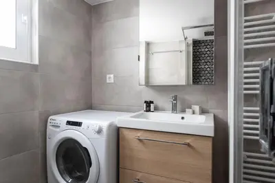 a bathroom with a washing machine and a sink at Faliro Seaside Retreat 2BD Apartment by UPSTREET in Athens