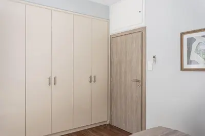 a bedroom with white cabinets and a closet at Faliro Seaside Retreat 2BD Apartment by UPSTREET in Athens