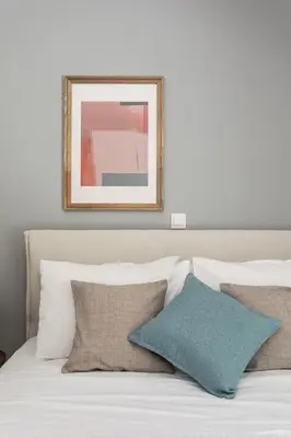 a white bed with pillows and a picture above it at Faliro Seaside Retreat 2BD Apartment by UPSTREET in Athens