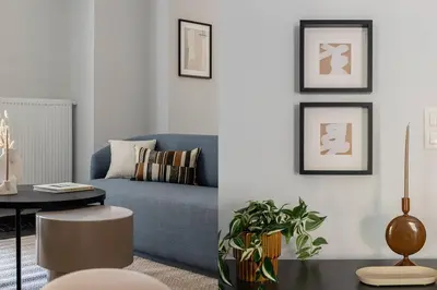 a living room with a blue couch and a table at Faliro Seaside Retreat 2BD Apartment by UPSTREET in Athens