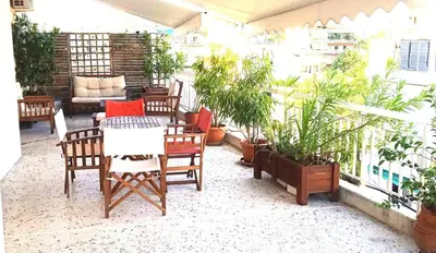 a patio with a table and chairs and plants at Flat 32 penthouse in Athens
