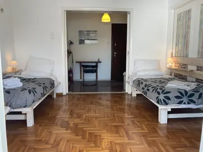 a room with two beds and a wooden floor at Flat 32 penthouse in Athens