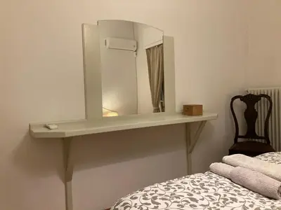 a shelf with a mirror on a wall next to a bed at Flat 32 penthouse in Athens