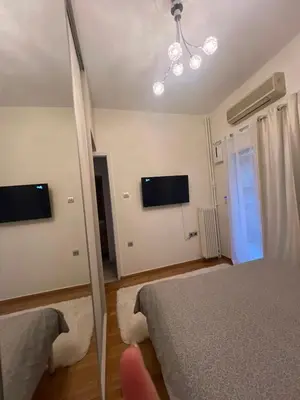 a bedroom with two beds and a television on the wall at Cozy Nest at Lykavitos in Athens