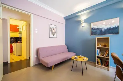 a living room with a pink couch and a table at City Romance in Athens