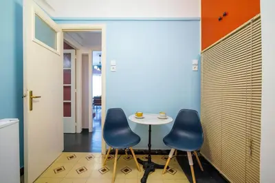 a dining room with two blue chairs and a table at City Romance in Athens