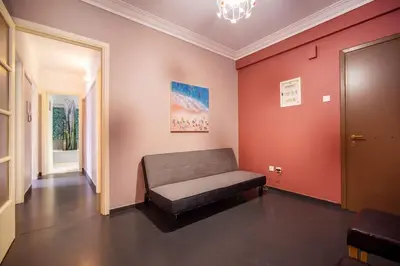 a room with a couch in a room with red walls at City Romance in Athens