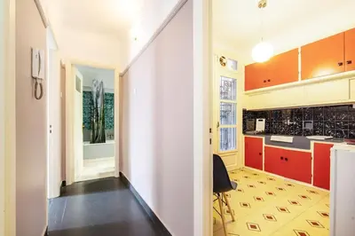 a kitchen with orange and white cabinets and a black floor at City Romance in Athens