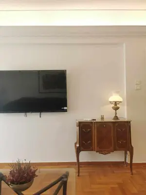 a living room with a tv on a wall with a table at Odel in Athens