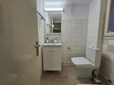 a white bathroom with a toilet and a sink at Athens Vibes Apartment by YHA in Athens