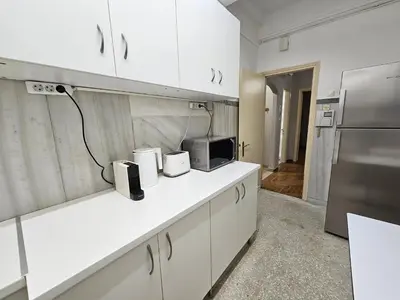 a kitchen with white cabinets and a refrigerator at Athens Vibes Apartment by YHA in Athens