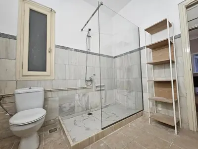 a bathroom with a toilet and a glass shower at Athens Vibes Apartment by YHA in Athens