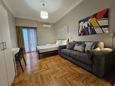 a living room with a couch and a bed at Athens Vibes Apartment by YHA in Athens