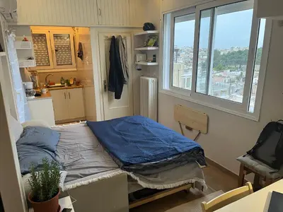 a small room with a bed and a window at Loft Pagrati in Athens