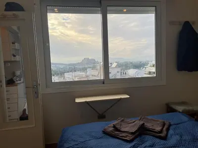 a bedroom with a bed and a window with a view at Loft Pagrati in Athens