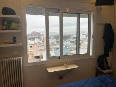 a bedroom with a window with a view of a city at Loft Pagrati in Athens