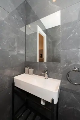 a bathroom with a white sink and a mirror at Kolonaki Elegant Apartment with Balcony in Athens