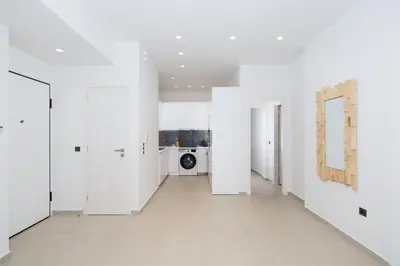 an empty room with white walls and a hallway with a washing machine at Kolonaki Elegant Apartment with Balcony in Athens