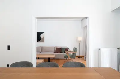 a living room with a couch and a table and chairs at Kolonaki Elegant Apartment with Balcony in Athens