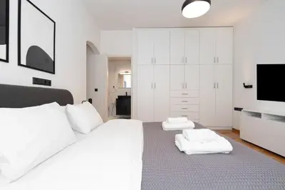 a bedroom with a white bed with two towels on it at Kolonaki Elegant Apartment with Balcony in Athens