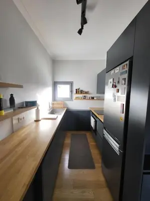 a kitchen with a refrigerator and a wooden counter at Painters apartment in Athens