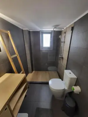 a small bathroom with a toilet and a window at Painters apartment in Athens