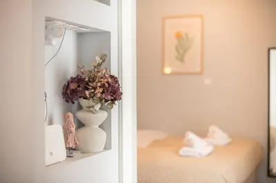 a room with a mirror and a vase with flowers at THEA Terrace 6th floor Apartment in Athens
