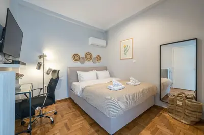 a bedroom with a bed and a desk and a mirror at THEA Terrace 6th floor Apartment in Athens