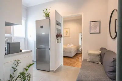 a kitchen with a refrigerator and a living room at THEA Terrace 6th floor Apartment in Athens