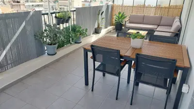 a table and chairs on a balcony with plants at THEA Terrace 6th floor Apartment in Athens