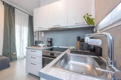 a kitchen with a stainless steel sink and a stove at THEA Terrace 6th floor Apartment in Athens