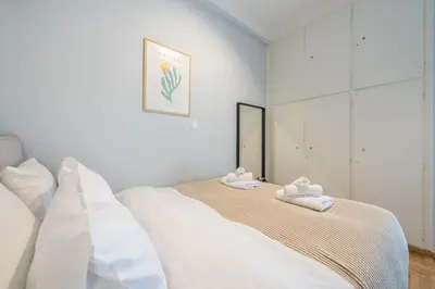 a white bedroom with a bed with towels on it at THEA Terrace 6th floor Apartment in Athens