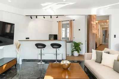a living room with a couch and a table at Luxury 4Bdrm Penthouse near Acropolis in Athens