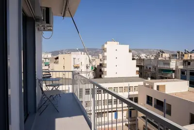 a chair on a balcony with a view of a city at Luxury 4Bdrm Penthouse near Acropolis in Athens