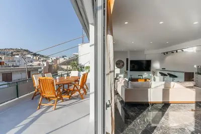 a room with a balcony with a table and chairs at Luxury 4Bdrm Penthouse near Acropolis in Athens