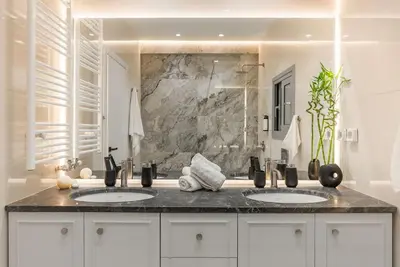a bathroom with two sinks and a stone wall at Luxury 4Bdrm Penthouse near Acropolis in Athens