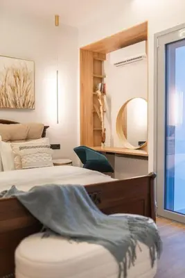 a bedroom with a bed and a chair and a mirror at Luxury 4Bdrm Penthouse near Acropolis in Athens