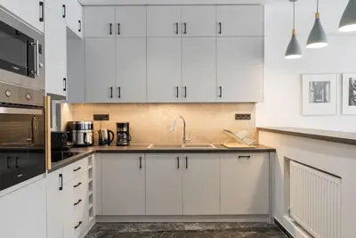 a kitchen with white cabinets and a sink at Luxury 4Bdrm Penthouse near Acropolis in Athens