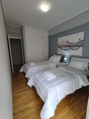 a bedroom with two beds with white sheets at Quiet and cozy apartment next to Acropolis in Athens