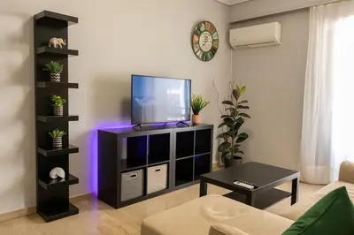 a living room with a flat screen tv on a entertainment center at Quiet and cozy apartment next to Acropolis in Athens