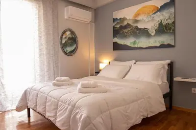 a bedroom with a white bed with two towels on it at Quiet and cozy apartment next to Acropolis in Athens