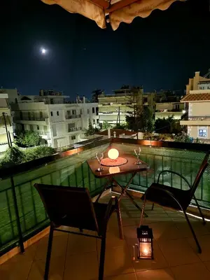 a table and chairs on a balcony at night at Luxury 2BR Ellinikon Apartment Oasis - Athens Riviera in Athens