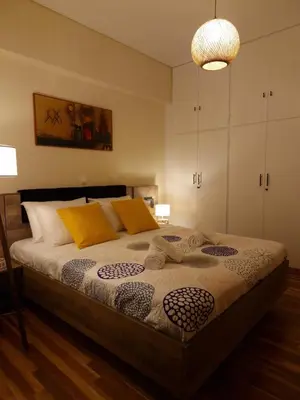 a bedroom with a large bed with yellow pillows at Luxury 2BR Ellinikon Apartment Oasis - Athens Riviera in Athens
