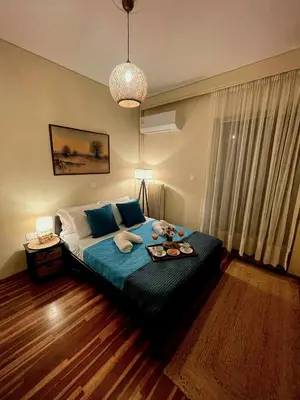 a bedroom with a large bed with a blue blanket at Luxury 2BR Ellinikon Apartment Oasis - Athens Riviera in Athens