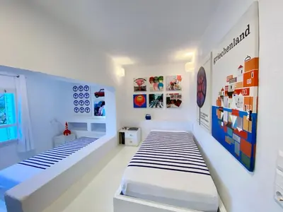 a white room with two beds in it at Hippie Bay Complex in Porto Rafti