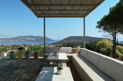 a patio with a table and a view of the water at Hippie Bay Complex in Porto Rafti