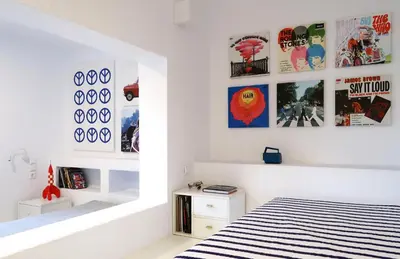 a white room with a bed and pictures on the wall at Hippie Bay Complex in Porto Rafti