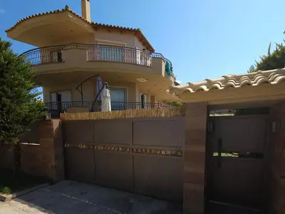 a house with a gate and a fence at Nefeli Villa lagonisi - Pool in Lagonissi